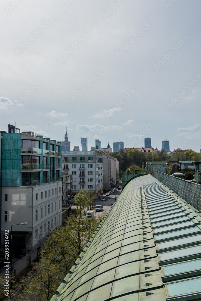 urban landscape with people cars and apartments and other buildings seen from the roof of a modern building on an early spring day urban landscape with people cars and apartments and other buildings seen from the roof of a modern building on an early spring day