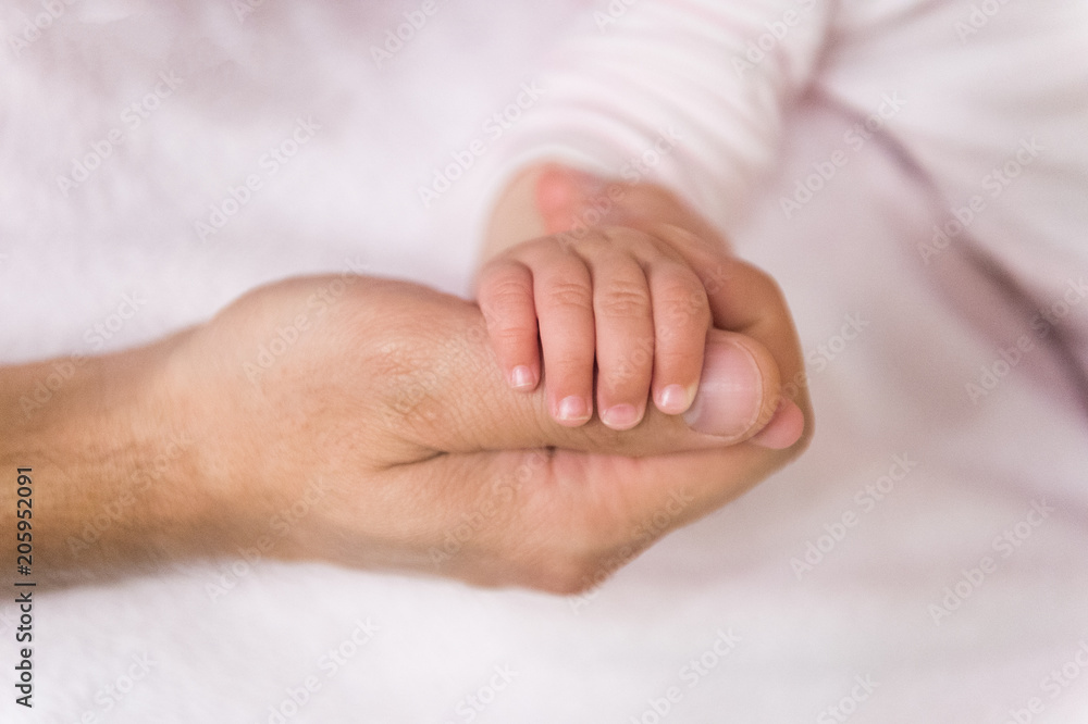 Baby hand hold male finger. Tiny hand. Fathers day concept. It is so tiny. Family love and trust. Childhood and carefree concept. Support of parents. unity and protection Baby hand hold male finger. Tiny hand. Fathers day concept. It is so tiny. Family love and trust. Childhood and carefree concept. Support of parents. unity and protection