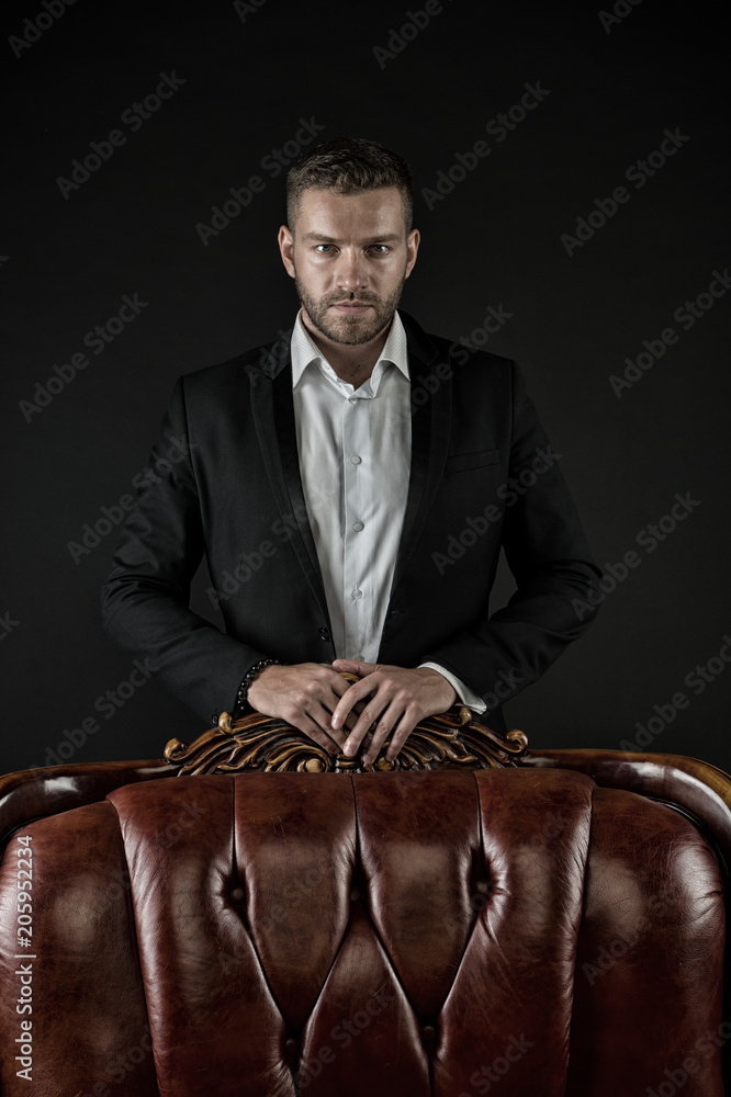 Confidence and charisma. Man stand at leather armchair on dark background.  Bearded man in formal suit. Businessman with beard and hairstyle. Business  fashion style and trend, vintage filter Photos | Adobe Stock