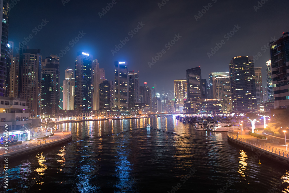 Dubai, United Arab Emirates - December 26, 2017: water canal on Dubai Marina skyline at night. Residential towers with lighting. Architecture or structure and design. Vacation and wanderlust