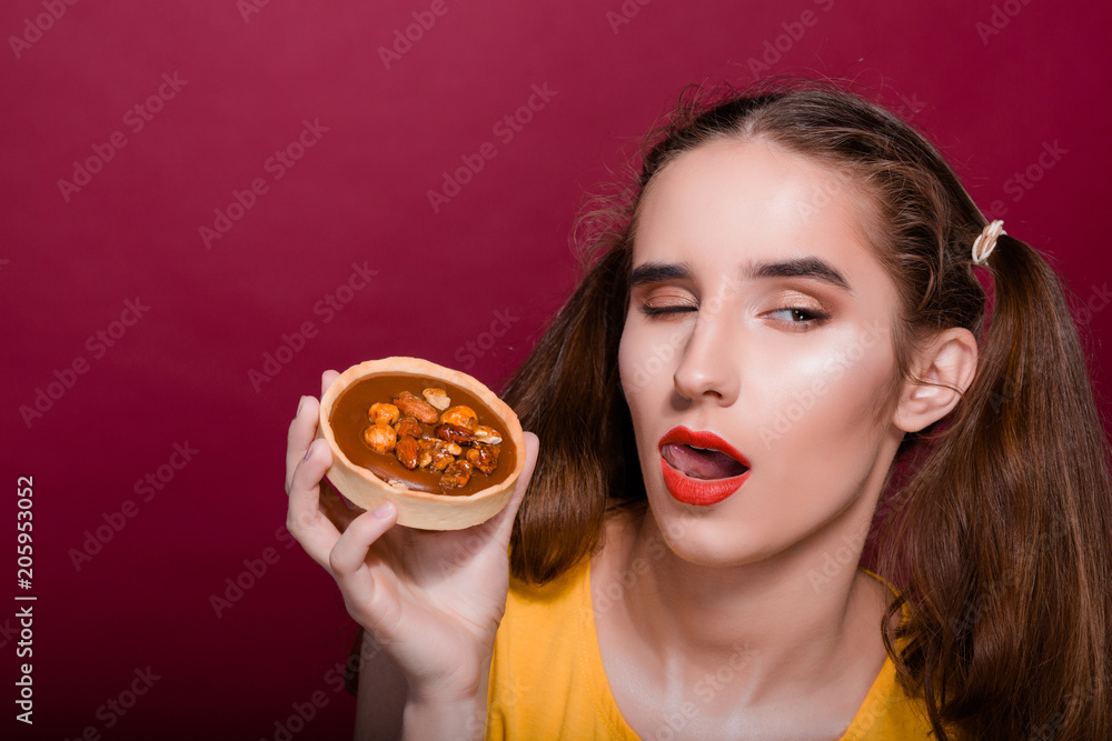 Merry brunette girl with red lips having fun with caramel tart cake. Empty space Merry brunette girl with red lips having fun with caramel tart cake. Empty space