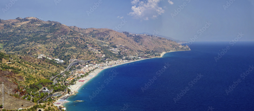 The coastline view from the Ruins of the Greek Roman Theater destroyed with Etna erupting, Taormina, Sicily, Italy