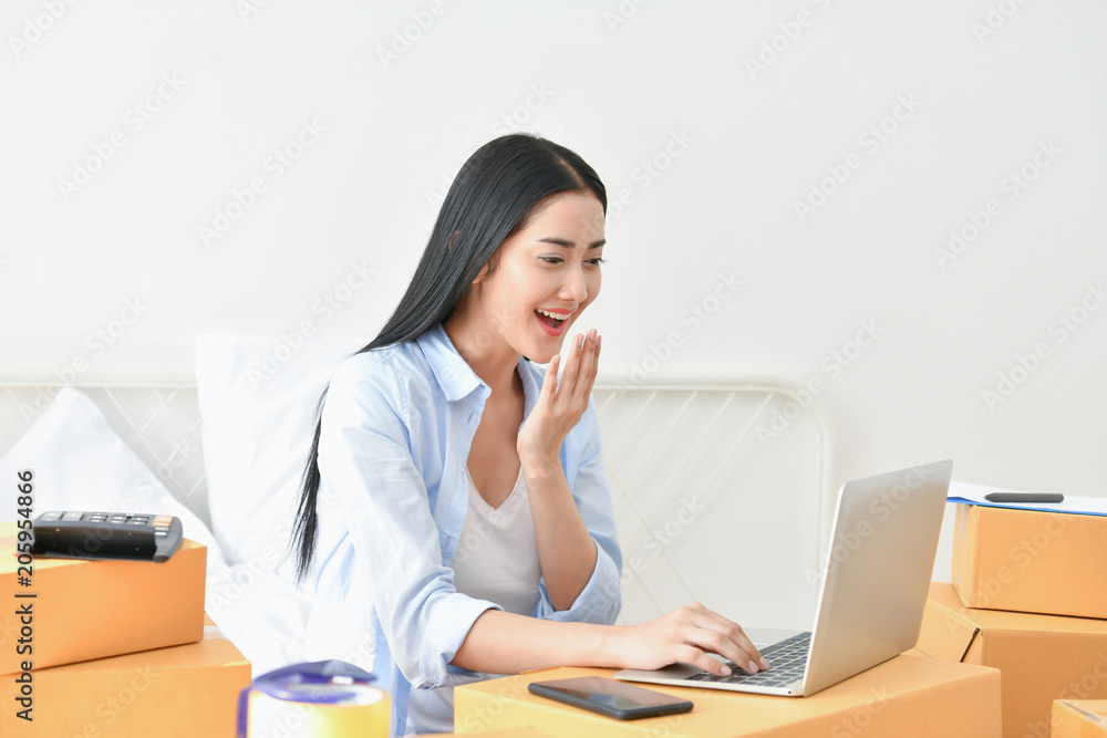 Sme business concept. Young people are packing their packages.Delivery business Small and Medium Enterprise (SMEs). Beautiful women are delighted in success. Sme business concept. Young people are packing their packages.Delivery business Small and Medium Enterprise (SMEs). Beautiful women are delighted in success.
