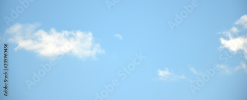 Blue sky background with clouds and moon
