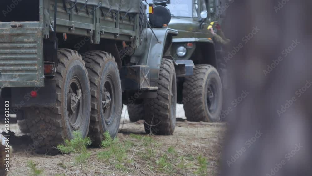 Soldiers in camouflage with combat weapons in the forest near the battle car, military concept Soldiers in camouflage with combat weapons in the forest near the battle car, military concept