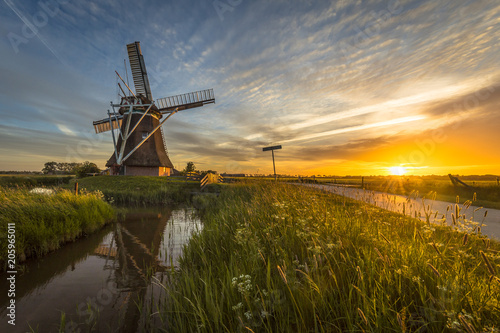 Wooden windmill canal cycling track at sunset © creativenature.nl