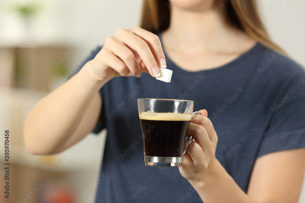 Girl hands throwing a sugar cube into a coffee cup Girl hands throwing a sugar cube into a coffee cup