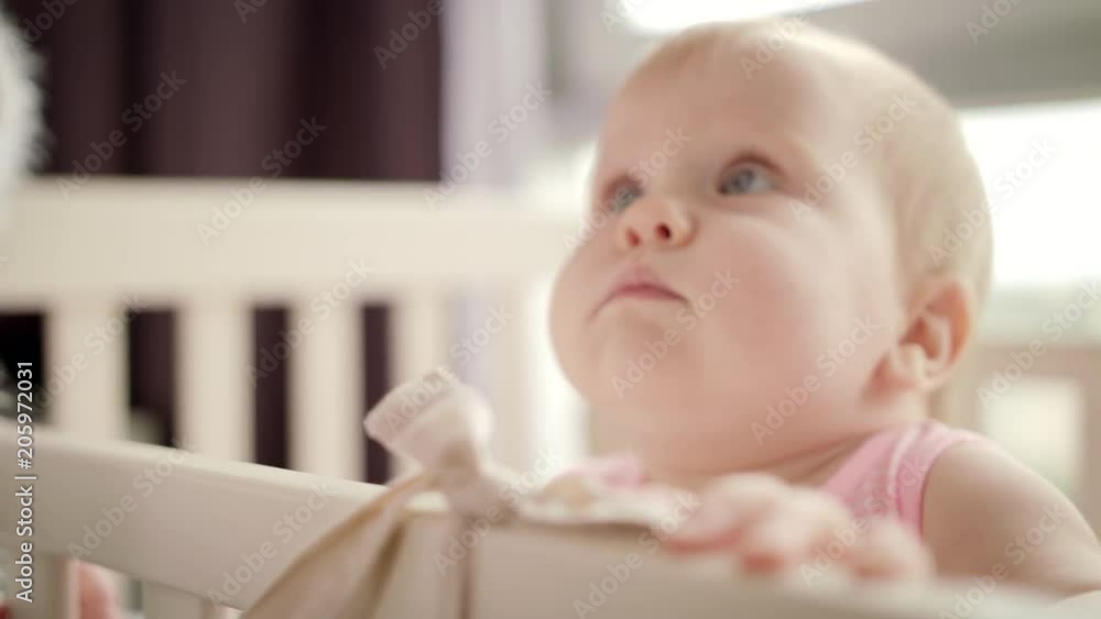 Adorable baby face in white crib. Close up of child portrait in bed. Cute toddler girl looking from cot. Sweet baby time. Lovely kid in bed. Beautiful infant face. Family love child Adorable baby face in white crib. Close up of child portrait in bed. Cute toddler girl looking from cot. Sweet baby time. Lovely kid in bed. Beautiful infant face. Family love child