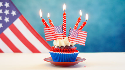 Red white and blue theme cupcakes with USA flags for Independance Day or USA theme party food.
