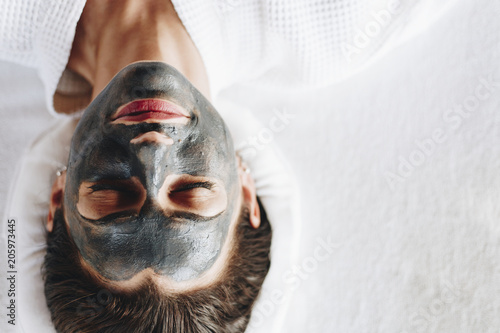 Photography Woman relaxing with a charcoal facial mask