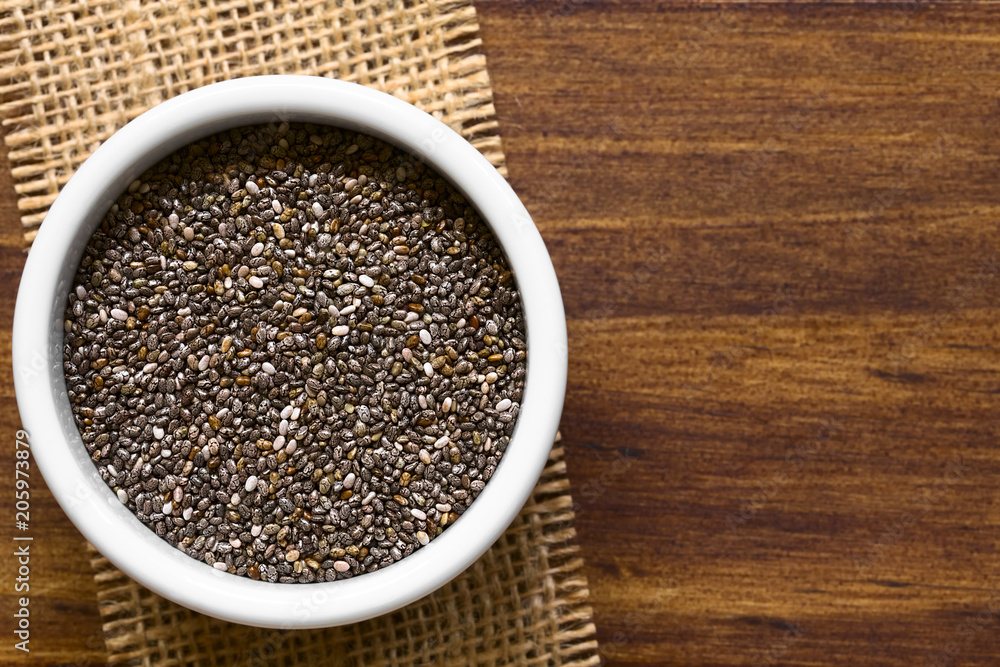 Healthy chia seeds (lat. Salvia hispanica) in small bowl, photographed overhead with natural light (Selective Focus, Focus on the top of the chia seeds) Healthy chia seeds (lat. Salvia hispanica) in small bowl, photographed overhead with natural light (Selective Focus, Focus on the top of the chia seeds)