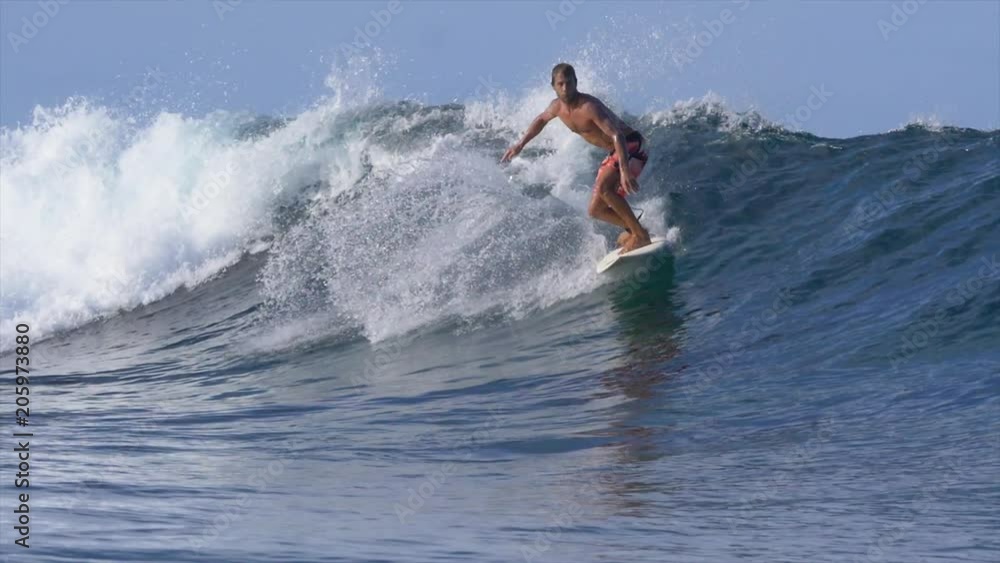 SLOW MOTION: Young pro male surfer rides a crystal clear breaking ocean wave. Extreme surfboarder on vacation rides an epic crashing wave on a perfect day for surfing. Man having fun on his surfboard. SLOW MOTION: Young pro male surfer rides a crystal clear breaking ocean wave. Extreme surfboarder on vacation rides an epic crashing wave on a perfect day for surfing. Man having fun on his surfboard.