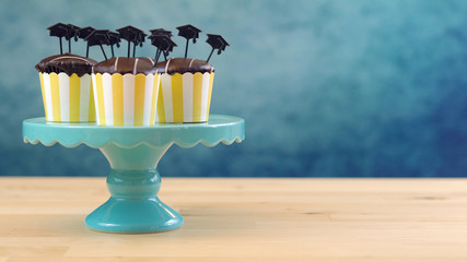 Yellow and blue theme graduation party cupcakes with cap hats toppers and decorations.