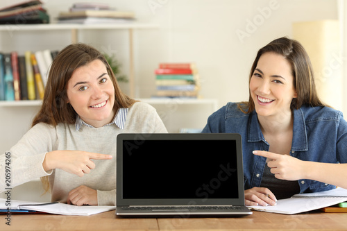Two students pointing at laptop screen mockup © Antonioguillem