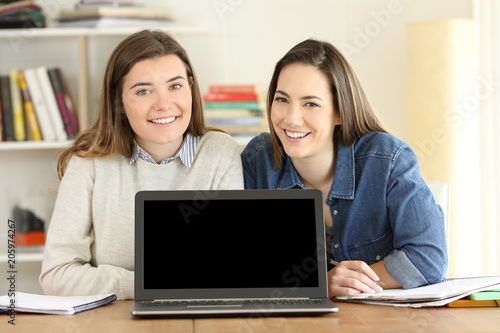 Two students showing a laptop screen mockup