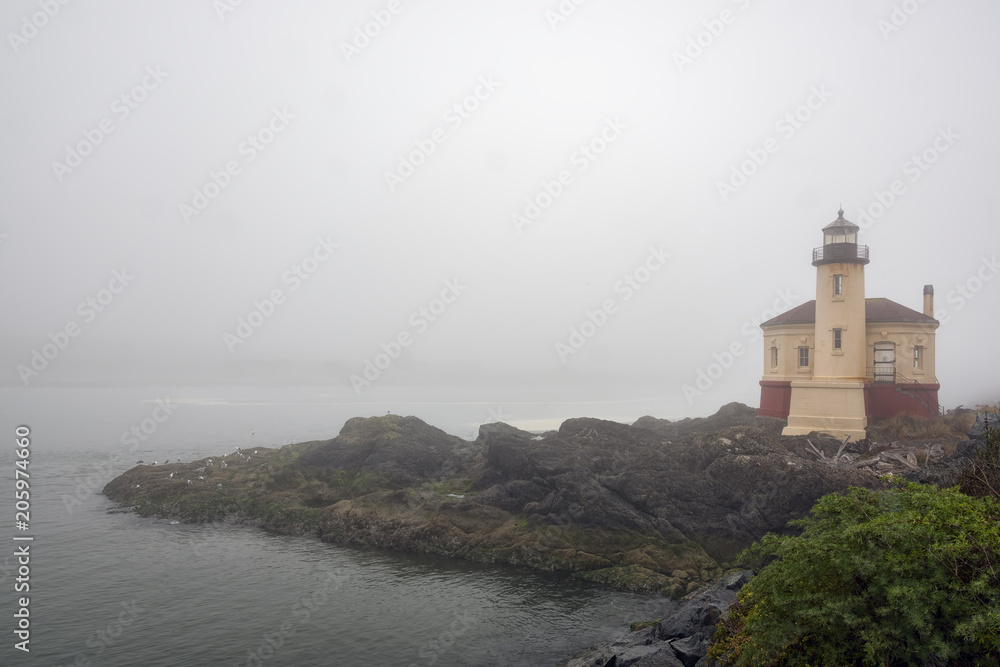 Heavy fog surrounds the Coquille River Lighthouse and the surrounding landscape near Bandon, Oregon