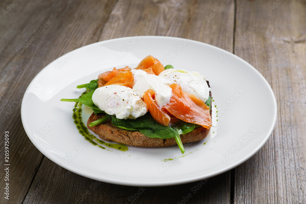 Wholemeal bread toast and poached egg with smoked salmon and spinach, healthy breakfast, restaurant menu photo, diet food