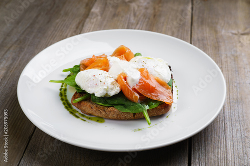 Wholemeal bread toast and poached egg with smoked salmon and spinach, healthy breakfast, restaurant menu photo, diet food