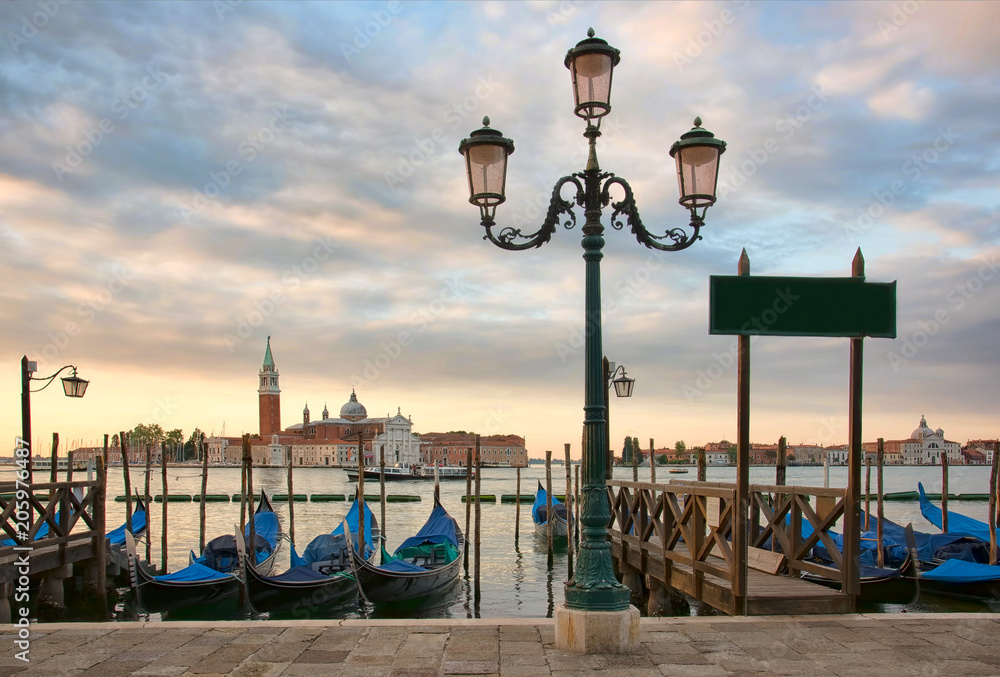 Gondolas and streetlamp in front of the San Giorgio Maggiore church in Venice at sunrise