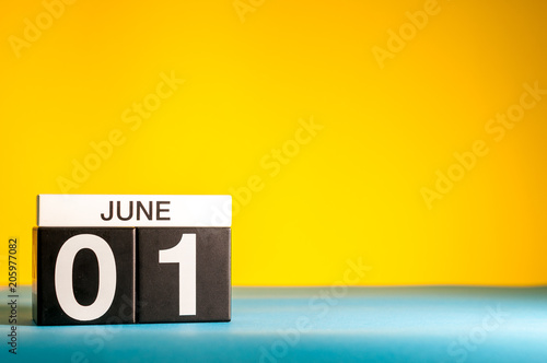 June 1st. Day 1 of june month, calendar on table with yellow background. Summer time, empty space for text