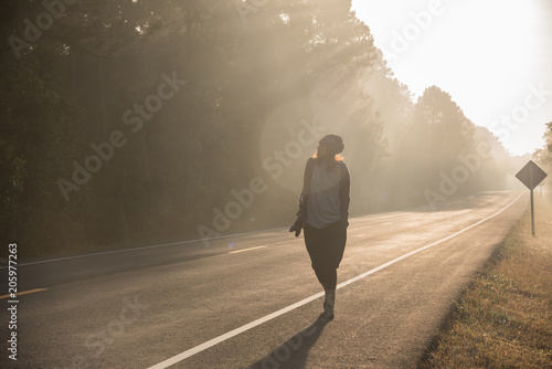 Happy Asian girl backpack in the road and forest background,