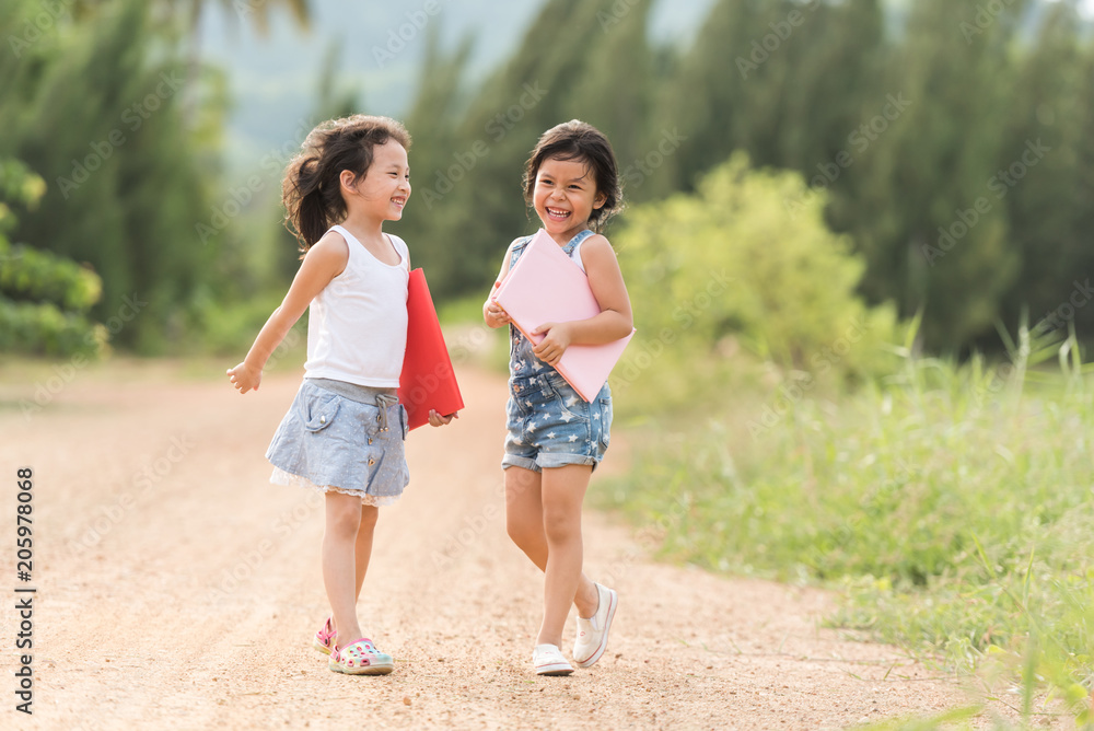 Ratchaburi, Thailand - June 18, 2017: two girl relaxxing with book near the road in country side Ratchaburi, Thailand - June 18, 2017: two girl relaxxing with book near the road in country side