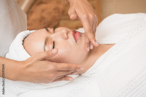 Face massage. Spa skin and body care. Close-up of young woman getting spa massage treatment at beauty spa salon. Facial beauty treatment.