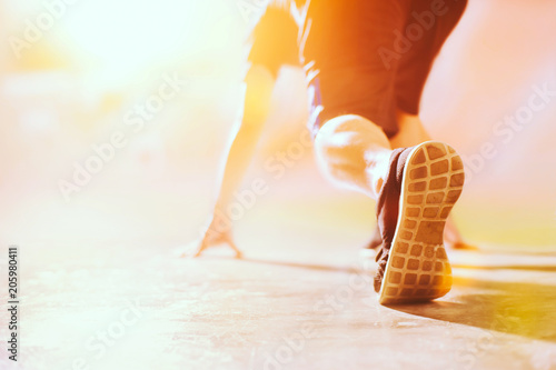 Athlete in running start pose on the street with copy space , Selected focus on shoe with blurry background .