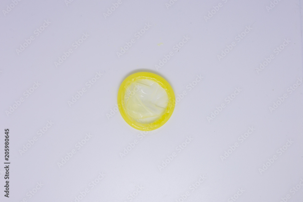 Fototapeta Close up of a yellow condom on white background