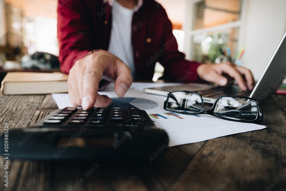 Fototapeta premium Close up view of bookkeeper or financial inspector hands making report, calculating or checking balance. Home finances, investment, economy, saving money or insurance concept