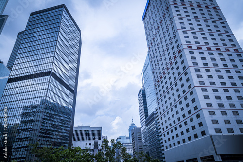 Bottom view of modern skyscrapers in business district against blue sky