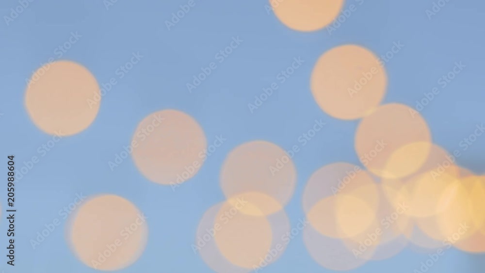 Gold and blue bokeh lights over an outdoor patio. Out of focus twinkle lights shine over a courtyard. The modern and trendy globe lights illuminate a wedding celebration below. Gold and blue bokeh lights over an outdoor patio. Out of focus twinkle lights shine over a courtyard. The modern and trendy globe lights illuminate a wedding celebration below.