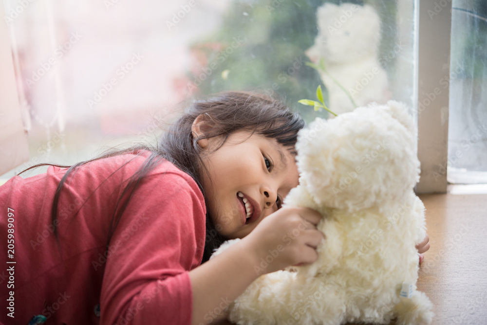 child little girl by the window with a teddy bear child little girl by the window with a teddy bear
