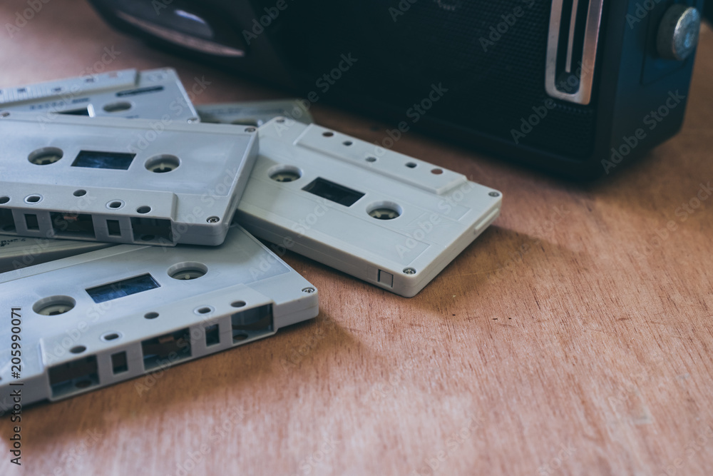 Audio cassette tapes with cassette player on wooden table Audio cassette tapes with cassette player on wooden table