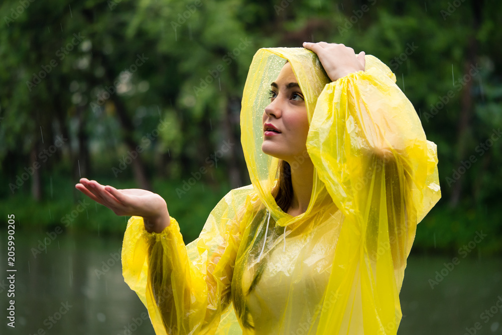 Ταπετσαρία Young beautiful happy woman in yellow raincoat enjoying the rain