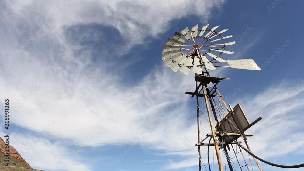 Looking up at a windmill spinning in the wind against a blue sky in Karoo South Africa.