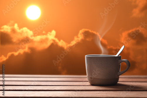 Morning cup of coffee or tea with sunrise background