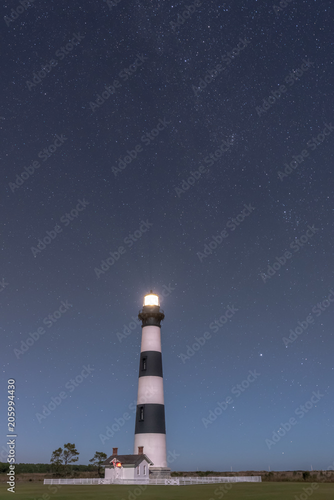NAGS HEAD, NC - OCTOBER 27, 2017:  The Bodie Island Lighthouse shines beneath a canopy of stars near Nags Head, NC on October 27, 2017.