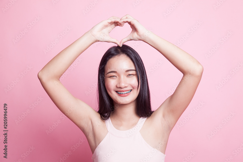 Young Asian woman gesturing heart hand sign. Young Asian woman gesturing heart hand sign.