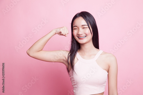 Beautiful young Asian woman flex bicep.