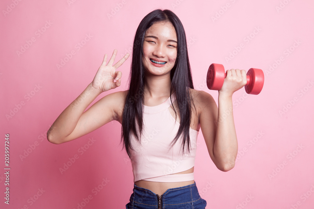 Healthy Asian woman show OK with dumbbells. Healthy Asian woman show OK with dumbbells.