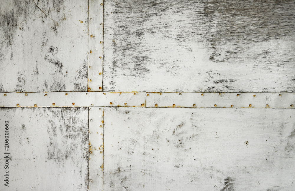 Wooden wall painted in white with iron plates on it Wooden wall painted in white with iron plates on it