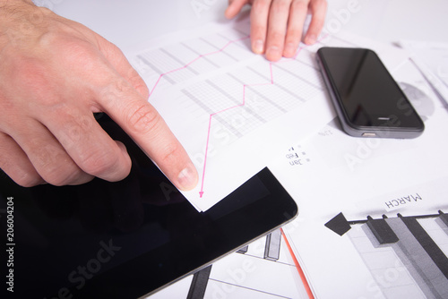 Fototapeta Naklejka Na Ścianę i Meble -  Hourglass. Businessman working in the office in the background. Concept time is money.