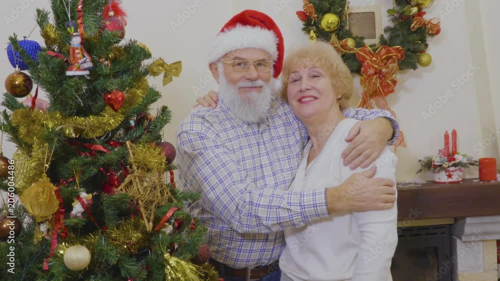 Happy mature couple decorate Christmas tree Happy mature couple decorate Christmas tree