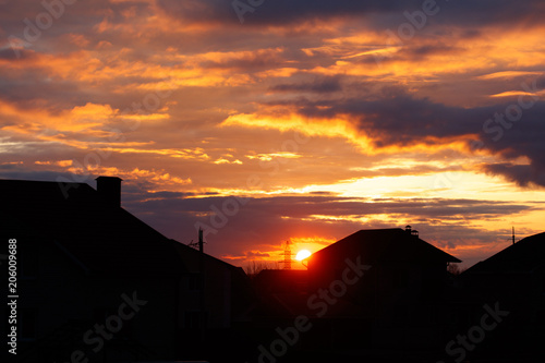 Sunset on the background of houses in the village © schankz