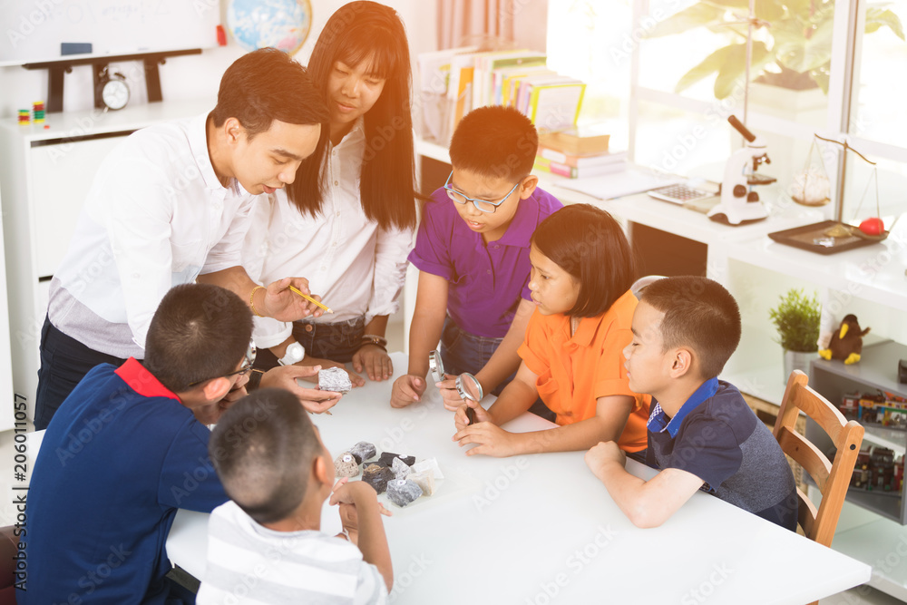 Cheerful male Teacher Explaining Something to a Group of Young Students