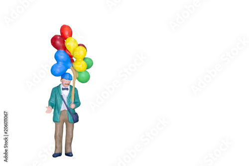 Miniature people holding balloon isolated on white background with clipping path.
