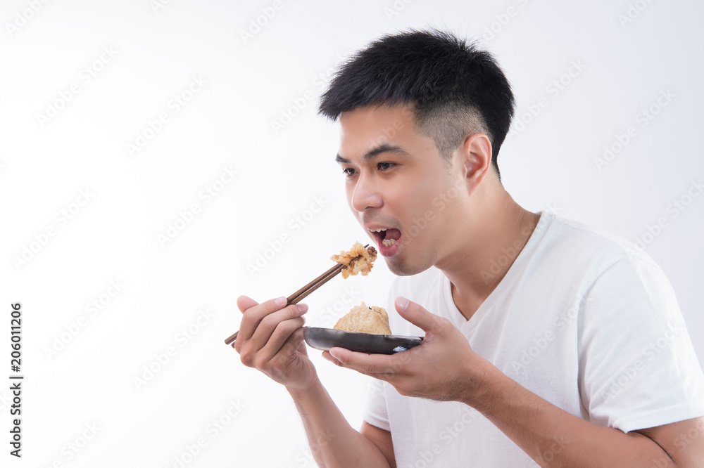 A man is going to eat delicious zongzi(rice dumpling) on Dragon Boat Festival, Asian traditional food, white background A man is going to eat delicious zongzi(rice dumpling) on Dragon Boat Festival, Asian traditional food, white background