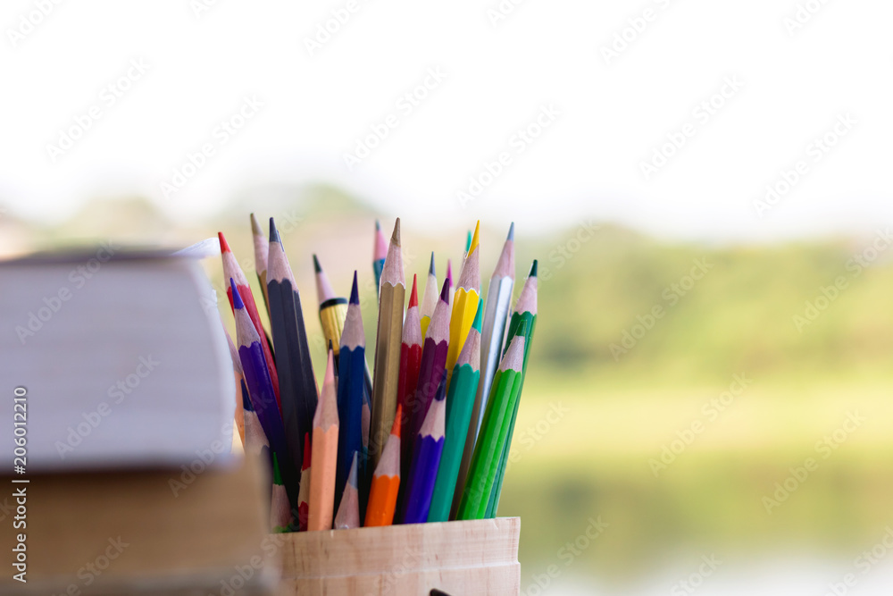 Fototapeta premium books and colorful pencils on wooden table lake background,Education concept.