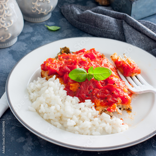 Flounder with tomato sauce and boiled rice, selective focus photo